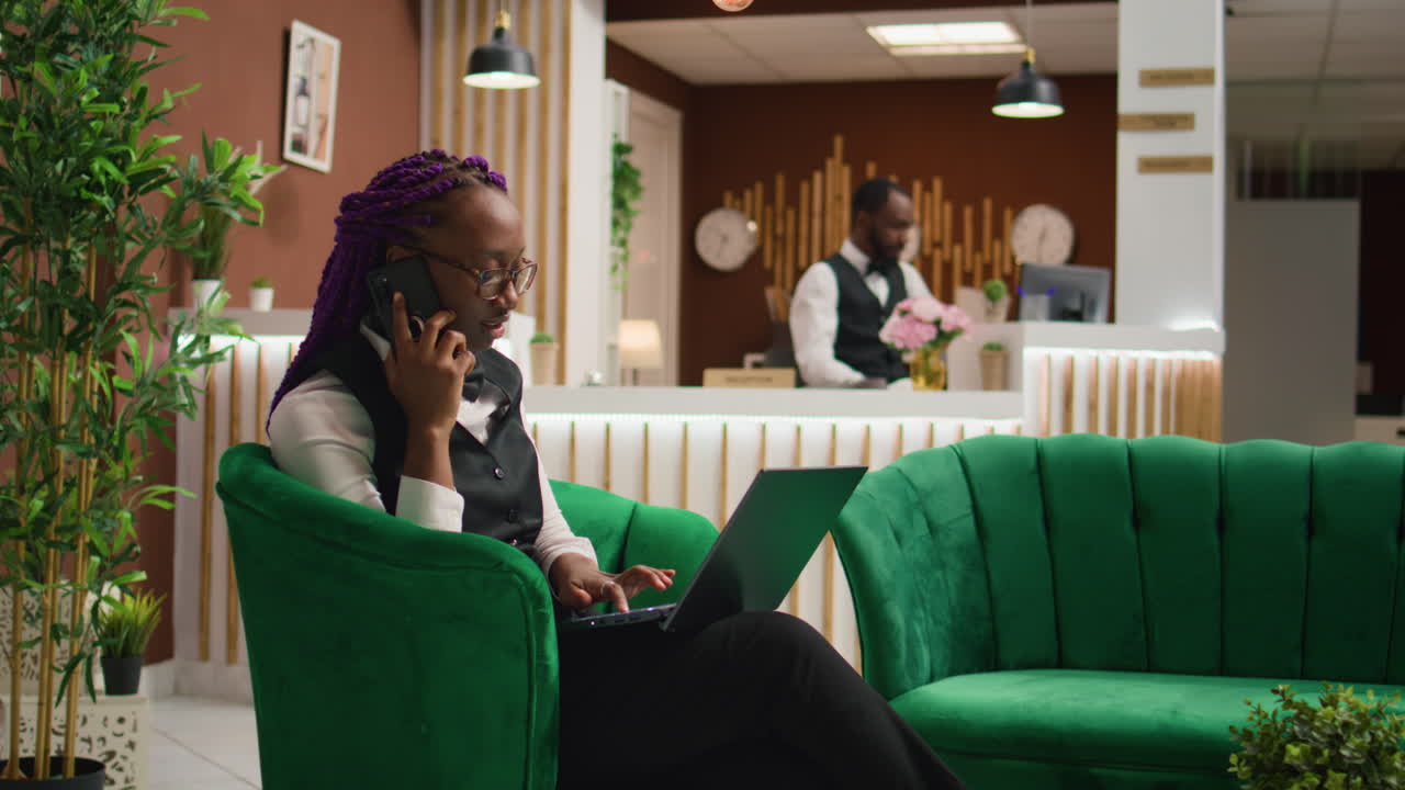 La receptionist afroamericana al telefono.