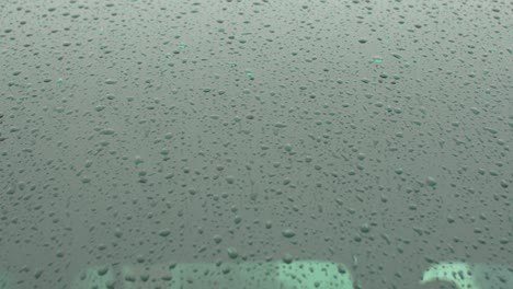 raindrops dripping on the car window. accumulation of liquid on the surface.