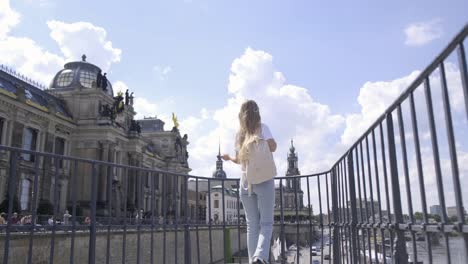 a woman happily enjoys a sunny day surrounded by majestic historical buildings while embracing the urban beauty