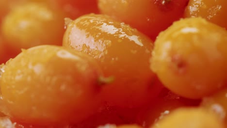 sea buckthorn healthy berries for tea drink, frozen ripe berries in glass jar and branches with leaves top view on dark wooden rustic background, great for skin, heart, vessels and immune system. copy space.