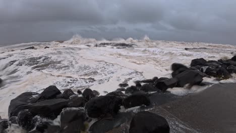 cyclone alfred - powerful waves crashing into the rocks with sea foam in queensland, australia. - wide shot