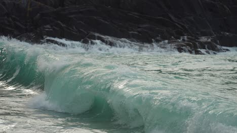 s primer plano de las olas rompiendo en la playa de arena