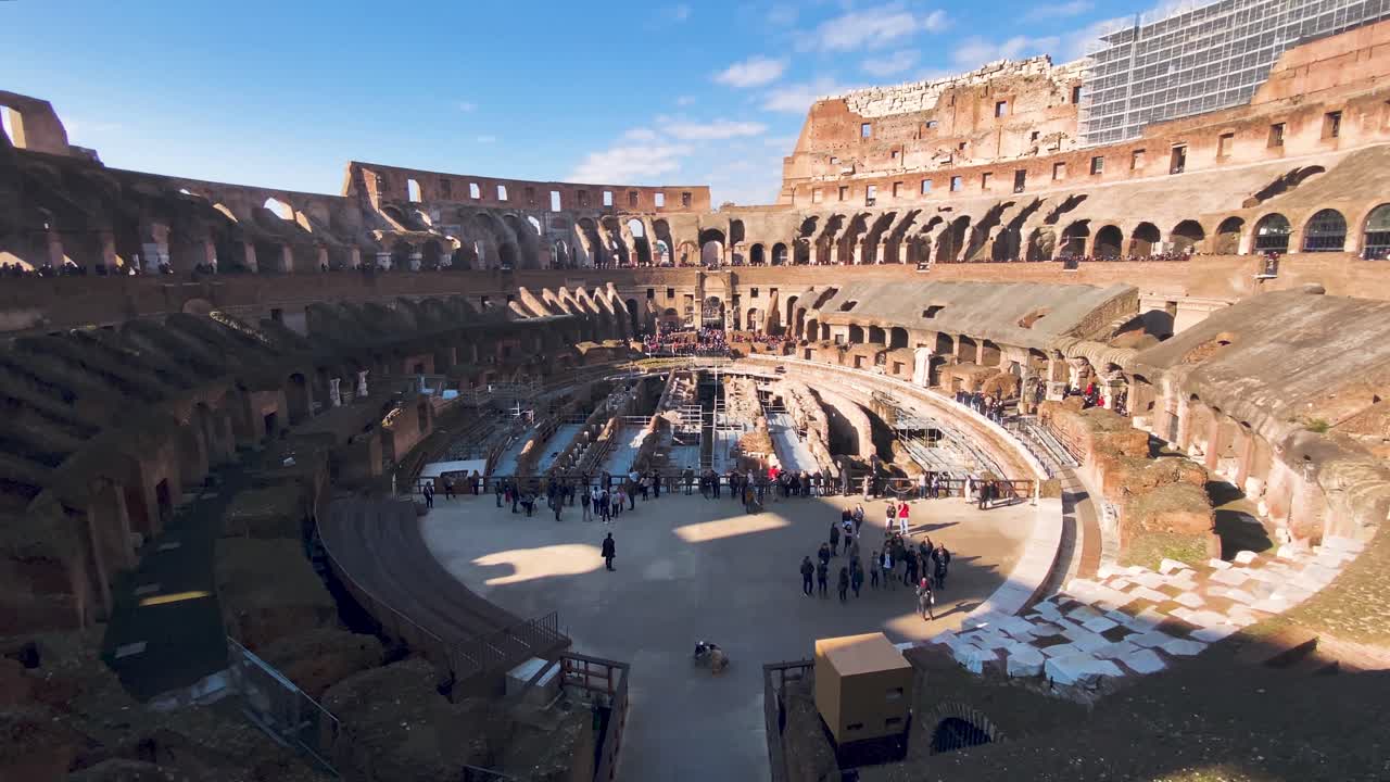 People At The Ancient Colosseum, Coliseum Or Flavian Amphitheatre On A Sunny Day In Rome, Italy. - panning up