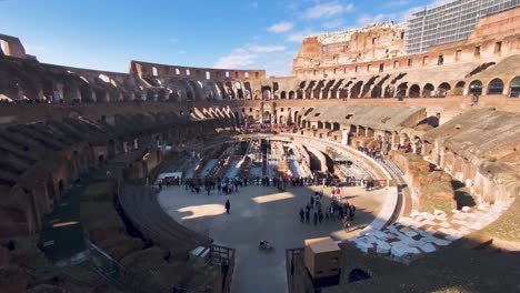 people at the ancient colosseum, coliseum or flavian amphitheatre on a sunny day in rome, italy. - panning up