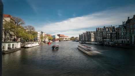 timelapse video of boat traffic on the amstel river running through amsterdam. in the distance, the city hall, national opera and theater can be seen.