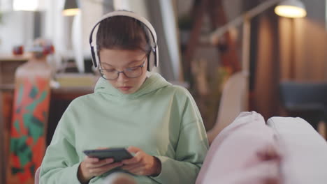 chica adolescente con auriculares jugando a un juego en una tableta