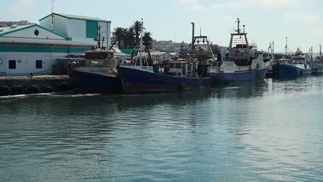 toma panorámica de barcos pesqueros atracados en un puerto tranquilo