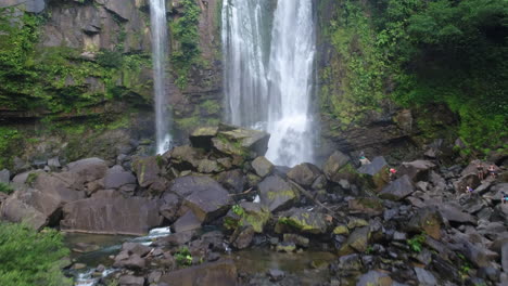 antena empujando hacia adelante del hombre parado en la base de la cascada nauyaca costa rica
