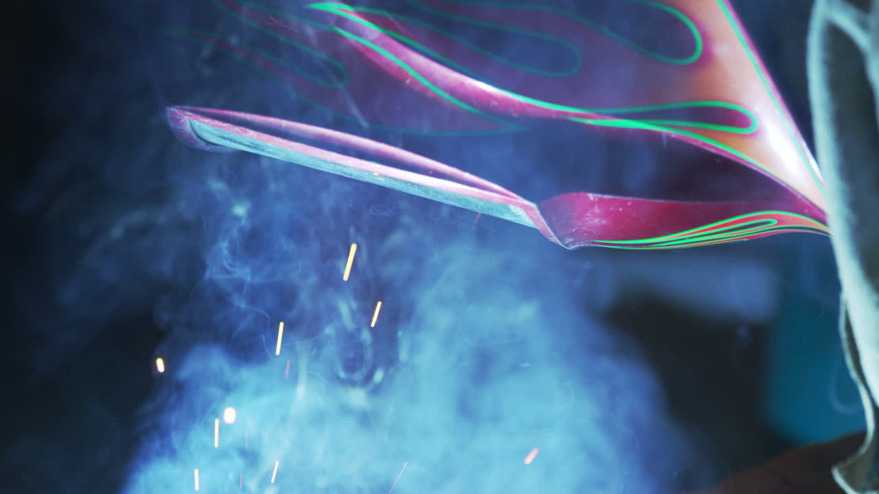 soldador con mascarilla protectora trabajando en una fábrica