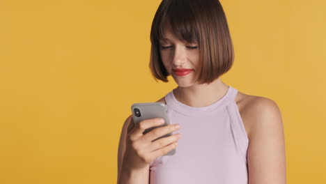 mujer feliz asintiendo con la cabeza mientras usa el teléfono inteligente