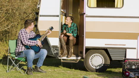 Novio-Frente-A-La-Autocaravana-Retro-Cantando-Con-La-Guitarra.