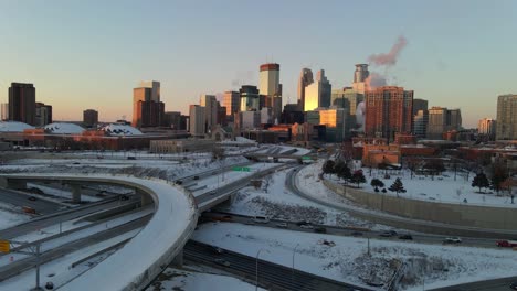 Aerial-footage-of-Minneapolis-downtown-skyline-and-main-highways-during-a-winter-golden-hour