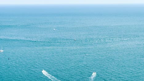 two speedboats are sailing apart from each other on the blue sea. handheld shot. dalkey, ireland. travel and tourism concept