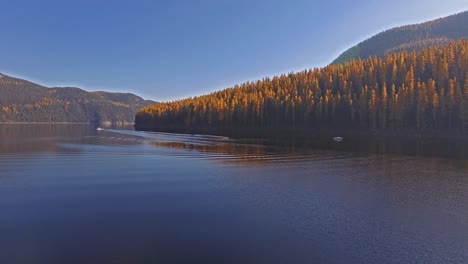 toma aérea de drones en montana en un lago con un bote en otoño o en otoño