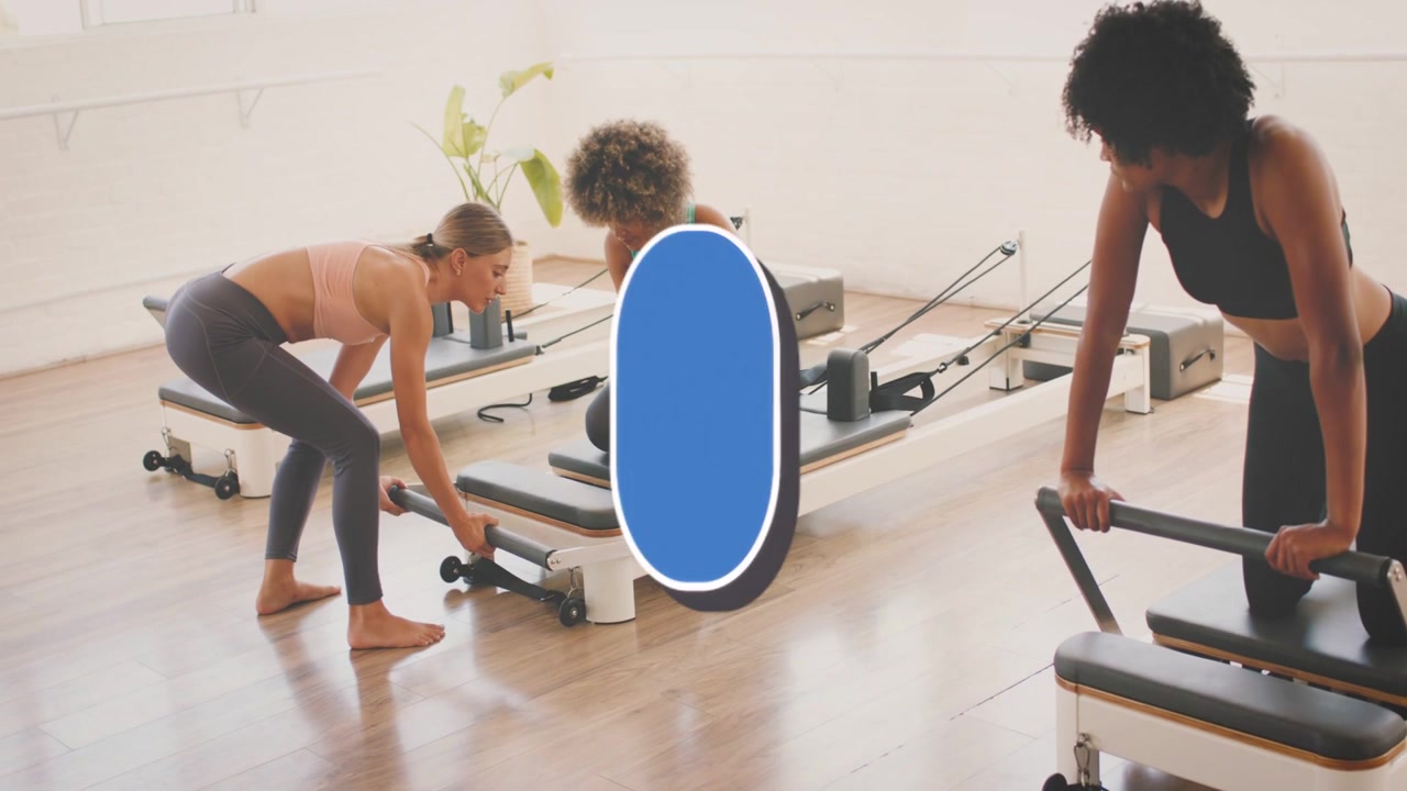 Tři ženy připravující pilates reformery, přičemž aktualizace „lajků“ vytváří modrý překryv nad skupinou propagující lekci.