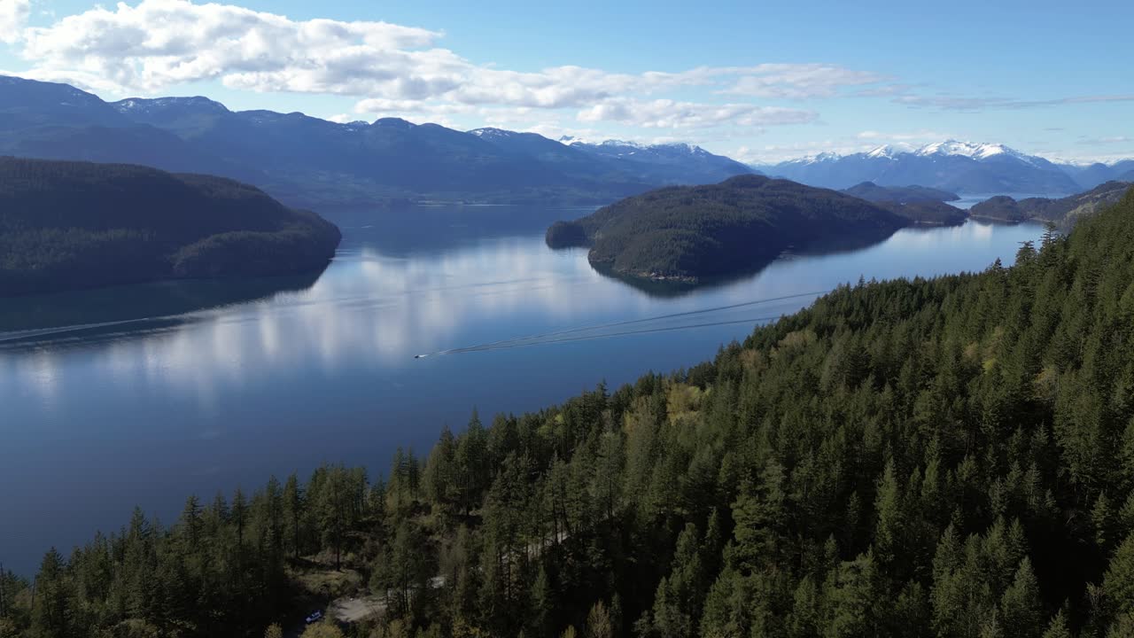 lago pintoresco y islas rodeadas de montañas en un día de primavera