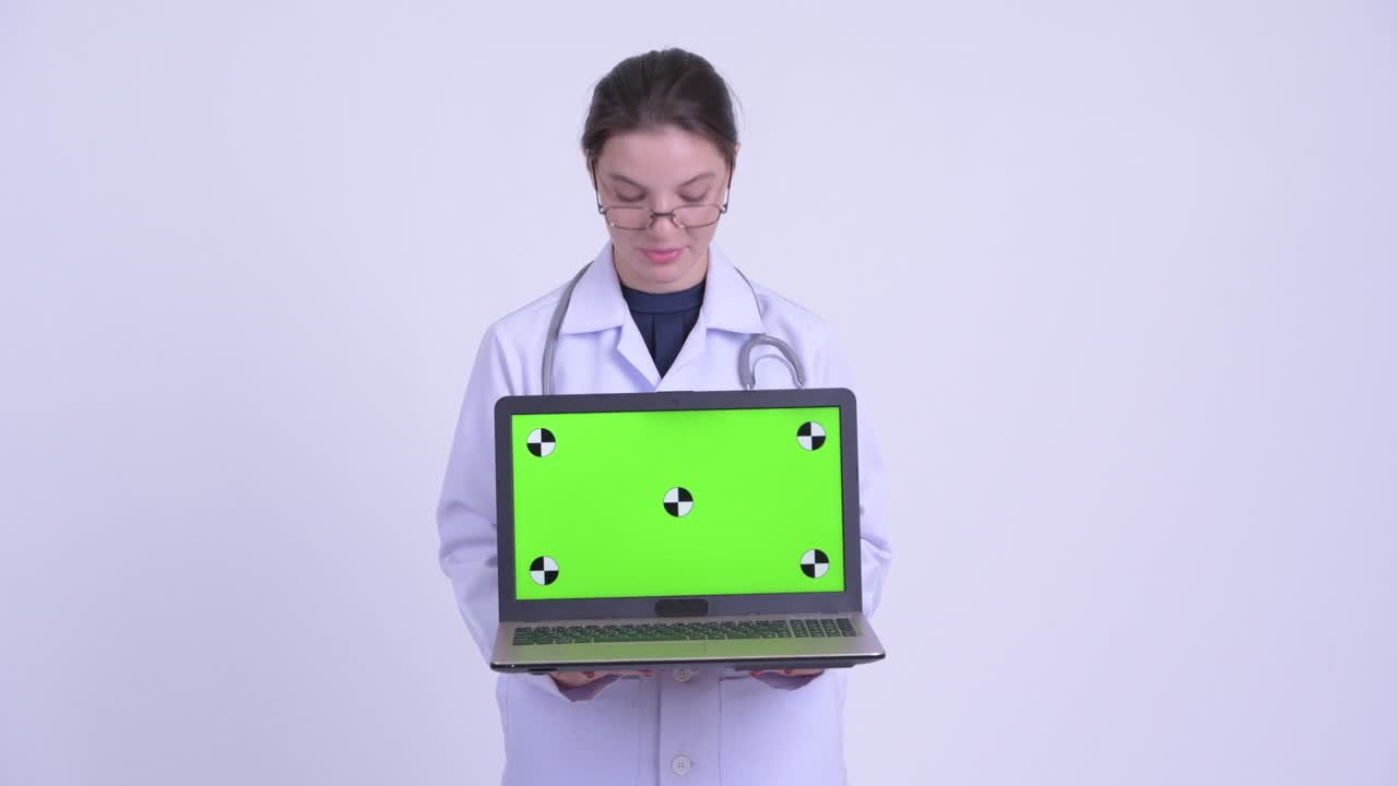 feliz joven hermosa mujer médico con computadora portátil