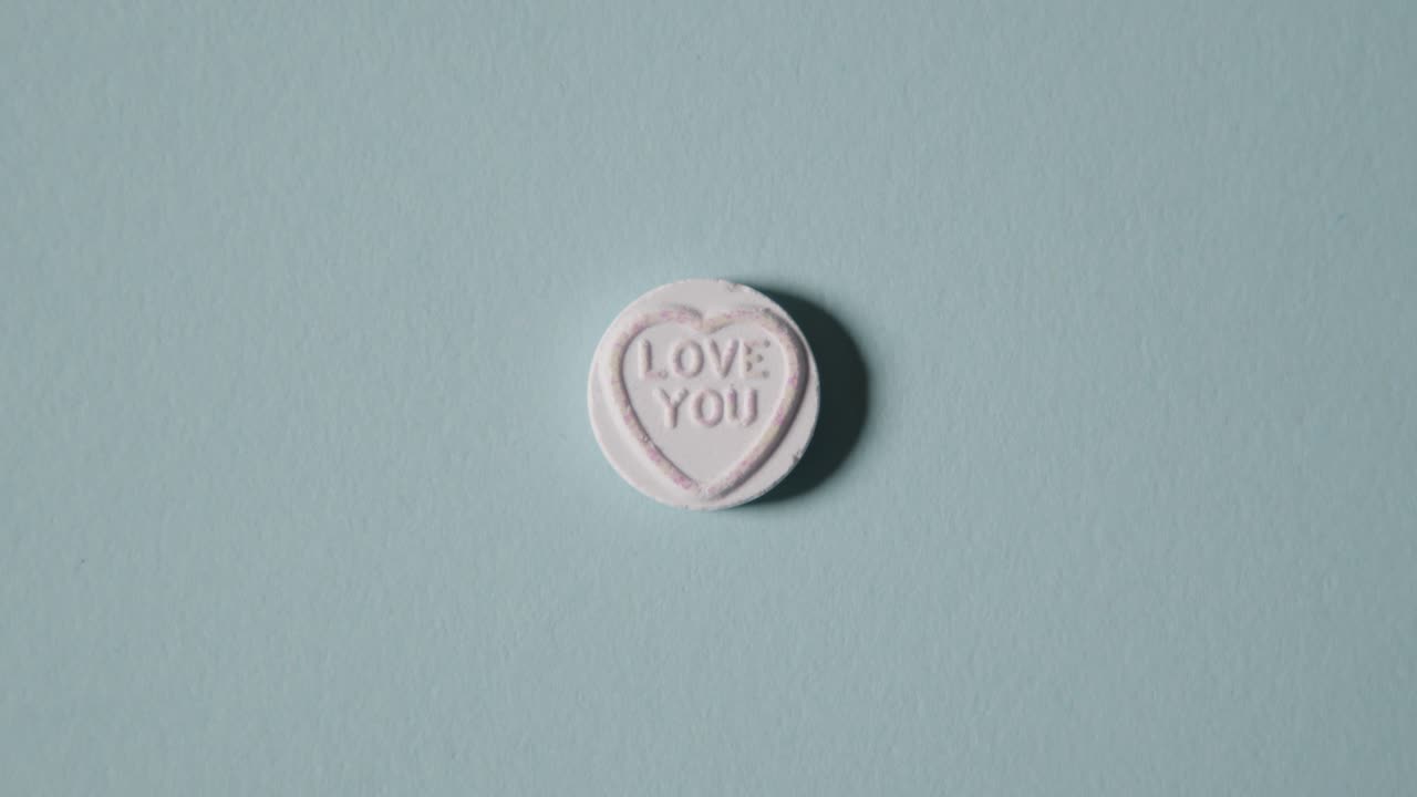 파란색 배경에 사랑 메시지와 함께 심장 사탕을 손에 들고