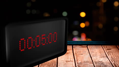 animation of digital clock counting down to midnight with lights on black background