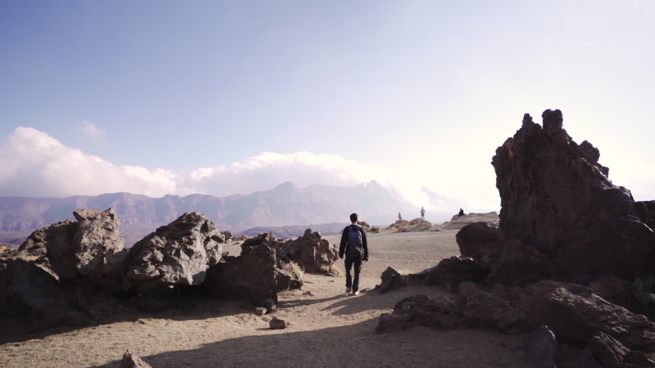 pan a la izquierda del hombre caucásico explorando el paisaje desértico en el parque nacional del teide
