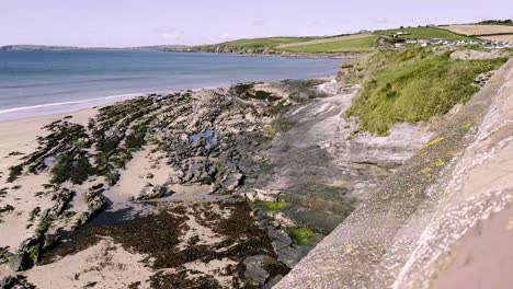 Zona-Costera-En-El-Condado-De-Cork,-Con-Rocas-Y-Acantilados-Y-Playa-De-Arena-Durante-La-Marea-Baja-Y-El-Día-Soleado