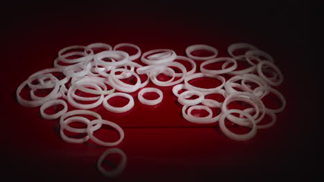 anillos de cebolla cayendo sobre la mesa. vista de cerca de la caída de cebolla de anillo en rodajas blancas.