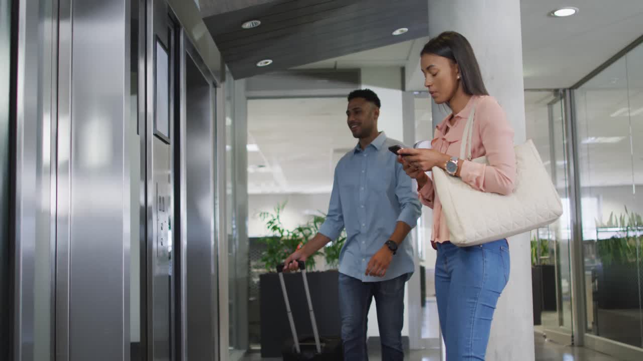 video di un uomo d'affari e una donna d'affari che aspettano l'ascensore