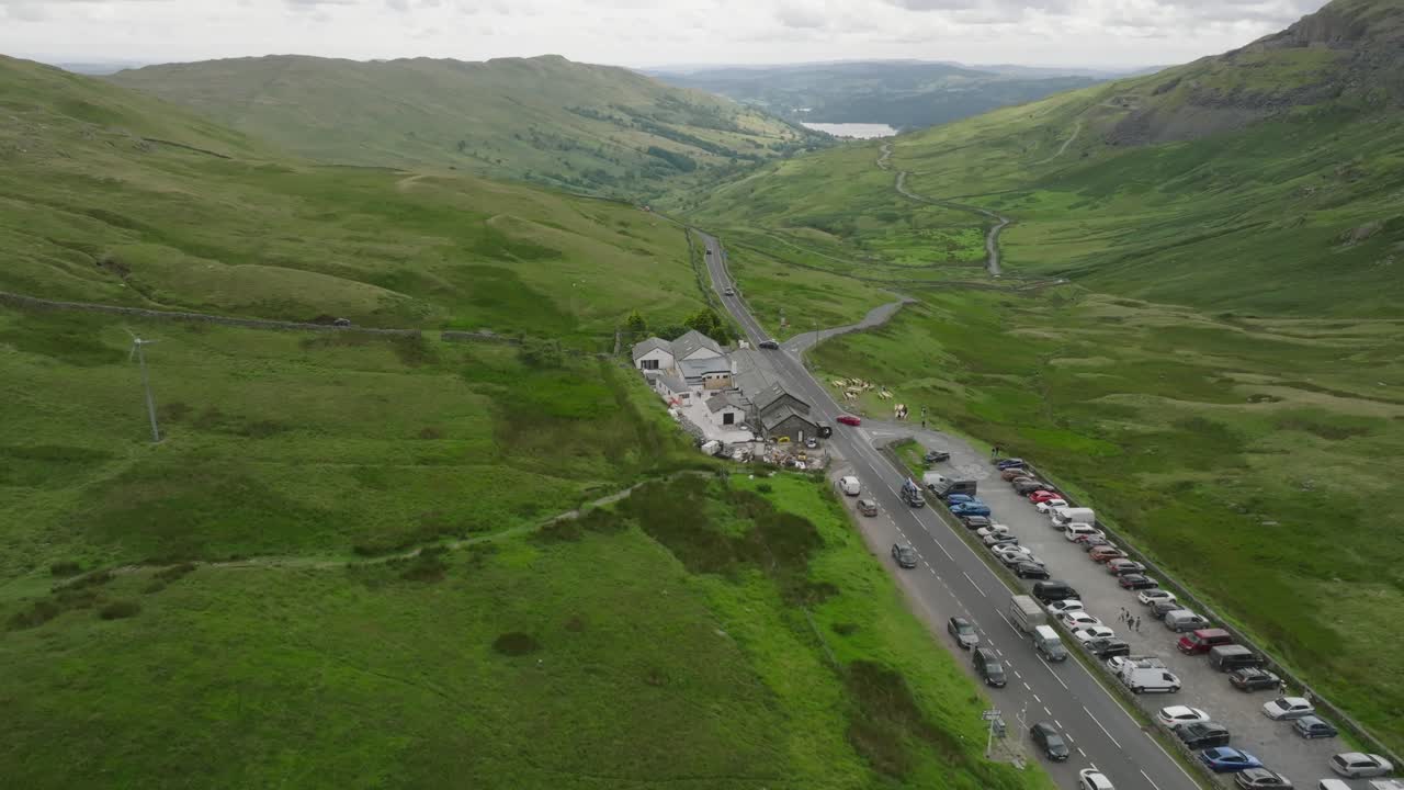 Busy Lakeland Road A592 With Kirkstone Pass Inn With Lake Windermere visible below. Summer. Kirkstone Pass, Lake District, Cumbria, UK