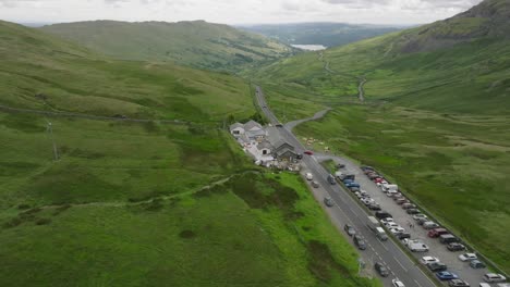 busy lakeland road a592 with kirkstone pass inn with lake windermere visible below. summer. kirkstone pass, lake district, cumbria, uk