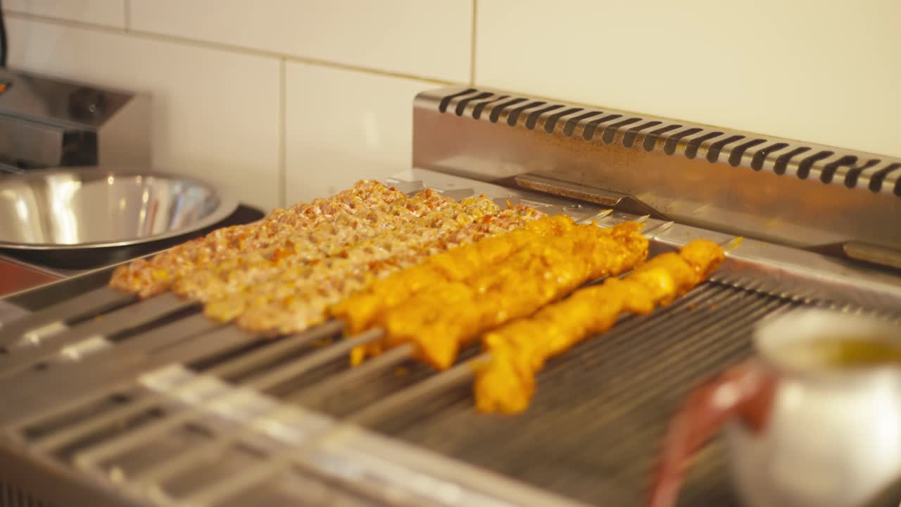 케 가게의 그릴, 따뜻한 조명 위에 긴 고기 스피어가 걱거리고 있습니다.