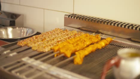 케 가게의 그릴, 따뜻한 조명 위에 긴 고기 스피어가 걱거리고 있습니다.