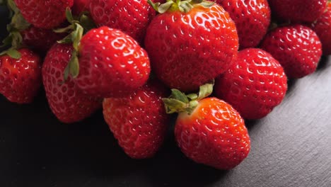 a lot of red and ripe strawberries rotating, closeup