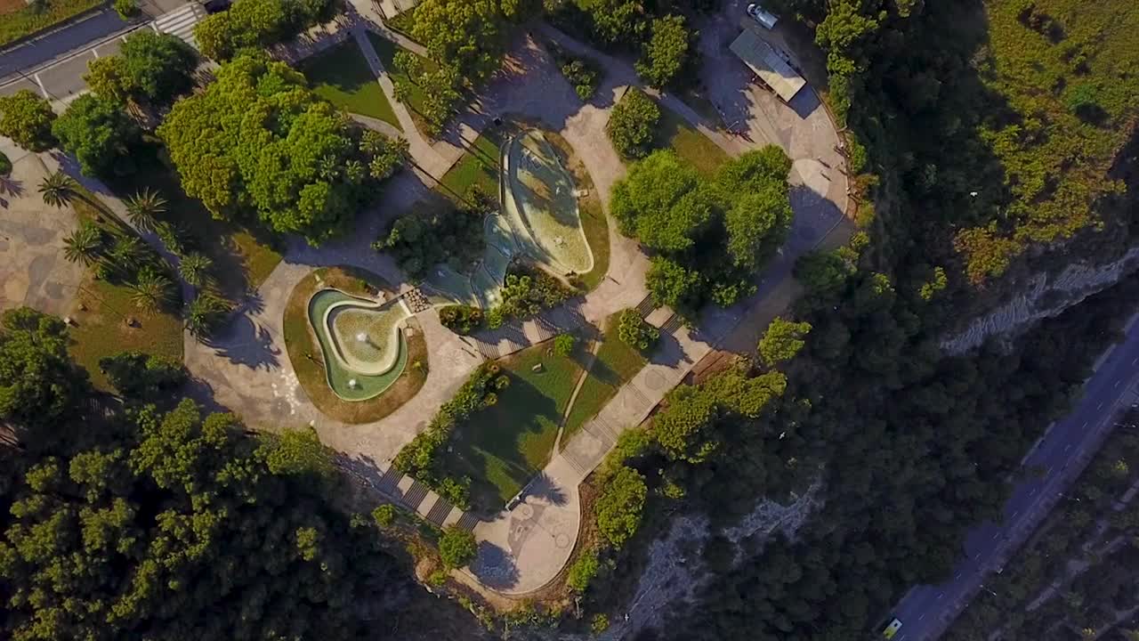 volando sobre el parque montjuic en un día soleado