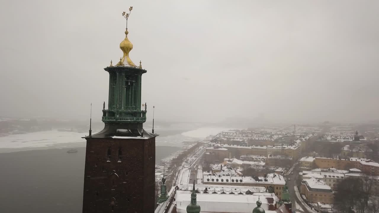 Jævn roterende luftoptagelse omkring Stockholms rådhus' klokketårn med byens skyline i baggrunden.