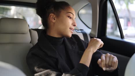 Carefree-Woman-In-Black-Clothes-Dances-While-Sitting-On-A-Backseat,-Listen-To-The-Radio-Or-Excited-About-Trip