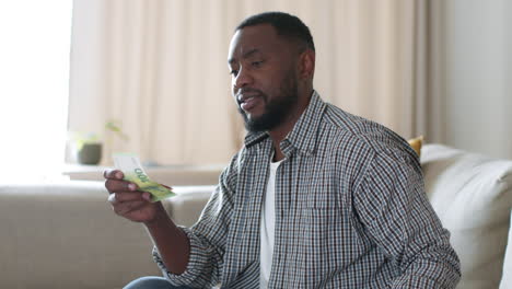 man interacting with a smartphone and money