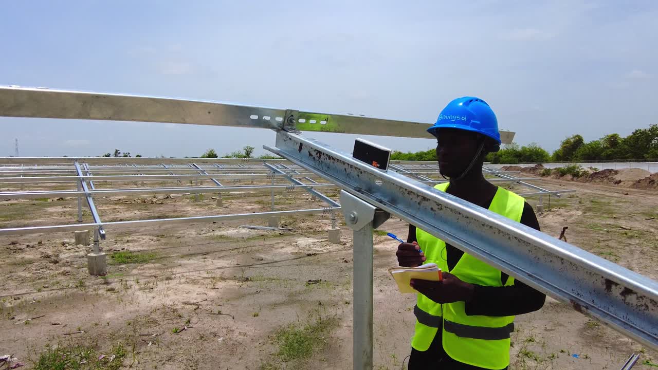 ingeniero africano negro tomando mediciones del ángulo de inclinación de la estructura de la matriz de paneles solares