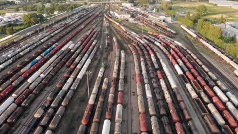 aerial dolly shot showing large train depot with many colorful cargo trains