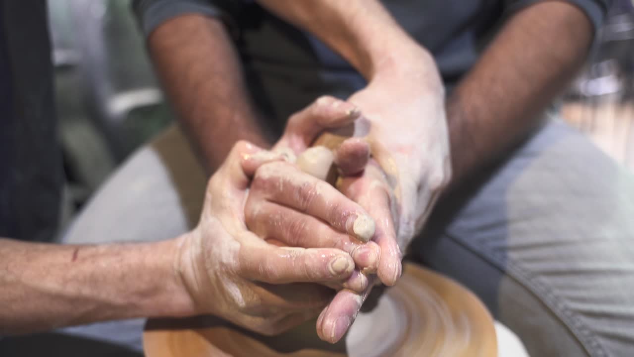 closeup de manos formando arcilla en una rueda de cerámica