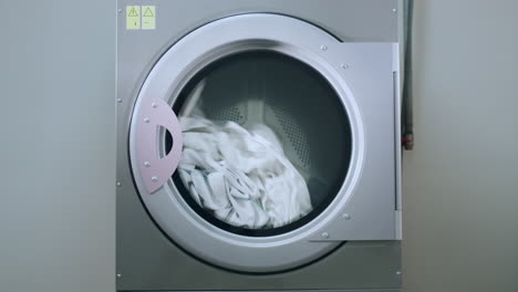 industrial washing machine washing clothes. closeup of laundry machine working