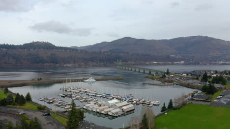 aerial view of a marina, bridge, and mountains on a river