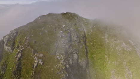 stave noruega aérea v20 vista de pájaro dron vuela alrededor del escarpado mirador de la montaña måtind capturando detalles rocosos y el paisaje marino costero rodeado de niebla espesa - filmado con mavic 3 cine - junio de 2022