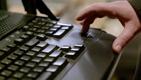 close-up of a hand on a laptop keyboard.