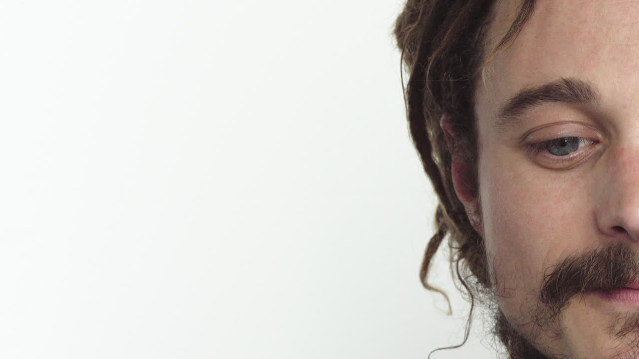 젊은 남자 반 얼굴 카우카시안 남성의 초상화  ⁇  배경에 고립 된 생각 많은 파란 눈