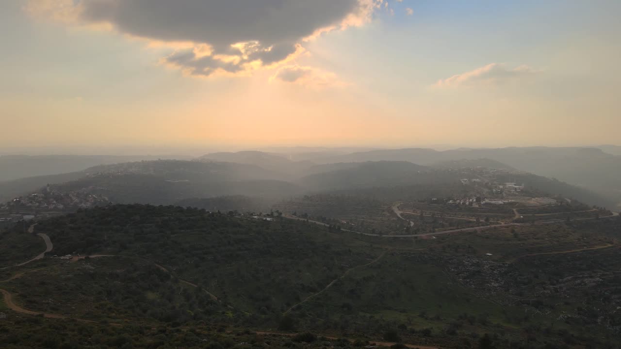mountains of Samaria and Judea, In Israel Aerial view.Sunset time and cloudy with fog in the valleys.Small settlements at the top of the mountains, Roads wind up the mountains