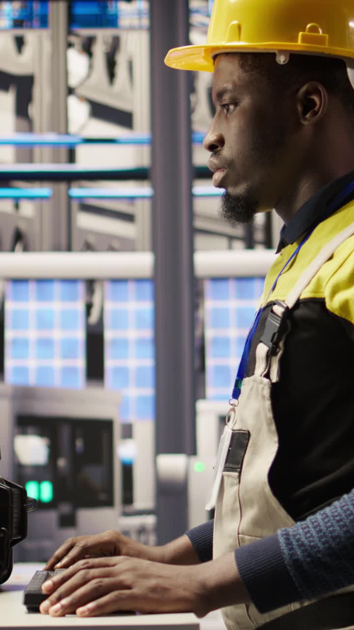 Vertical video Solar panels plant engineer uses PC to oversee systems