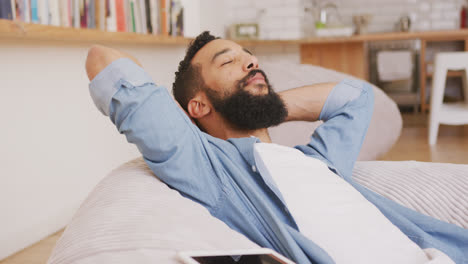 man relaxing with eyes closed on a bean bag indoors