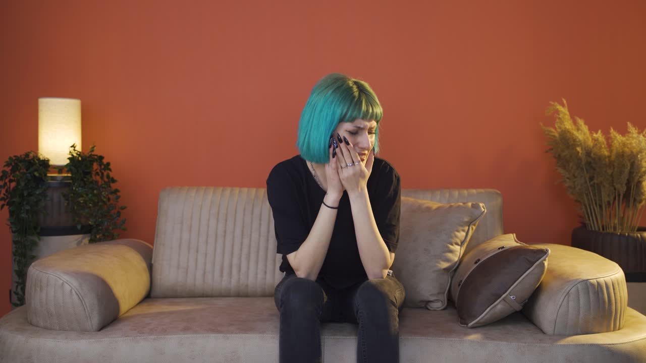 Sad young woman crying at home.