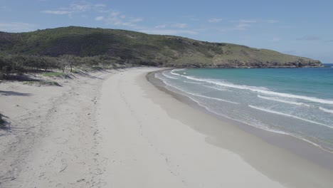 Unberührter-Wrackstrand-Mit-Meereswellen,-Die-An-Einem-Sonnigen-Sommertag-Plätschern