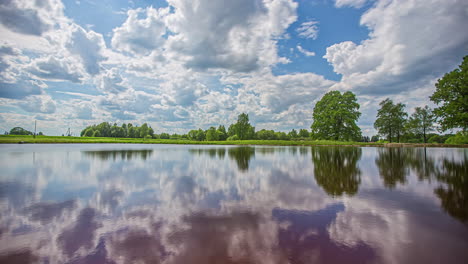 a dynamic cloudscape reflecting off the surface of a lake - summer time lapse